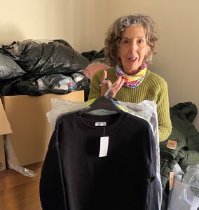 A woman is holding some clothes on a hanger.